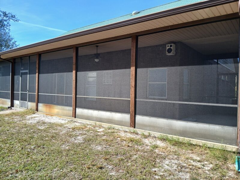 Screened porch enclosure with dark solar screen and an aluminum kickplate along the base